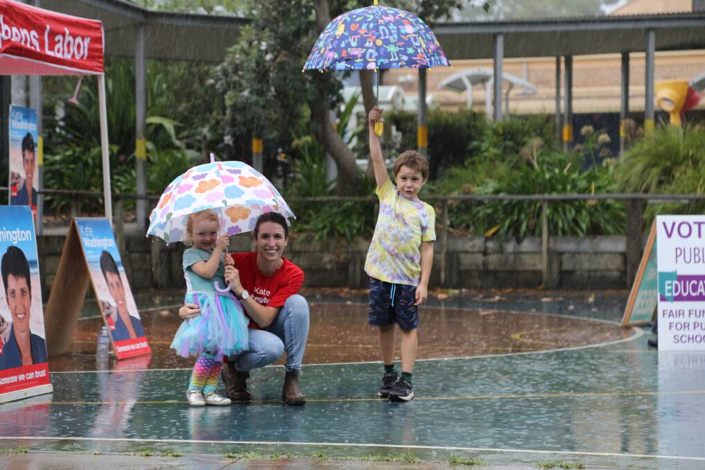 Labor volunteer Jacqueline Rimington with children Teddy, 5, and Juniper, 3, brave the rain for democracy in Medowie on Saturday afternoon. Picture by Ellie-Marie Watts