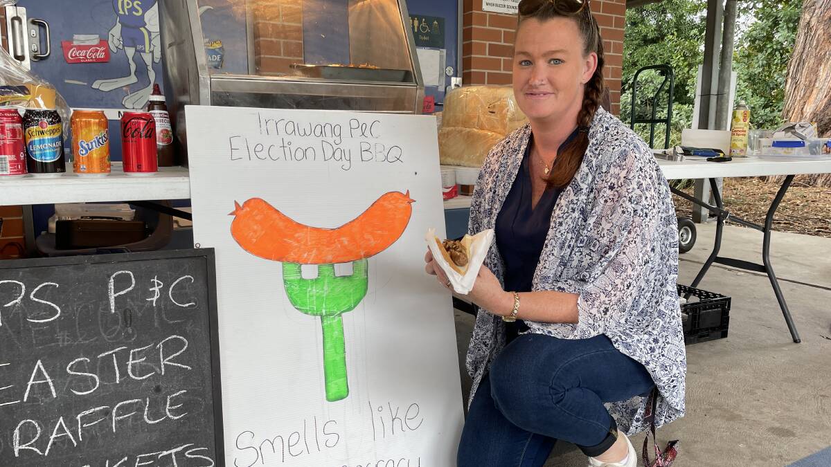 It smells like democracy at Irrawang Public Schools election day barbecue in Raymond Terrace. Pictured is Bec Pollard holding a democracy sausage.